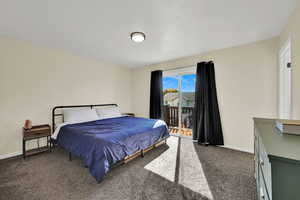 Carpeted bedroom featuring baseboards and access to exterior
