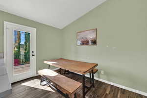 Dining space with vaulted ceiling and wood finished floors