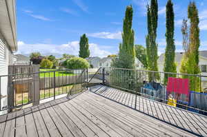 Wooden deck featuring a residential view and a lawn