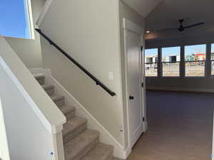 Stairs featuring wood finished floors and ceiling fan