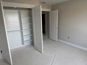 Unfurnished bedroom with a closet and baseboards