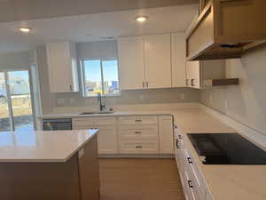 Kitchen with white cabinetry, light stone counters, and recessed lighting