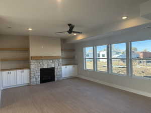 Unfurnished living room with a fireplace, a ceiling fan, light wood-style flooring, and recessed lighting