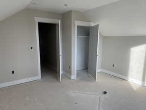 Unfurnished bedroom featuring lofted ceiling, a closet, and a textured ceiling