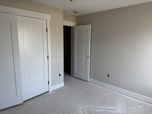 Unfurnished bedroom with baseboards and concrete flooring