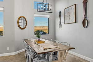 Dining space featuring baseboards and a chandelier