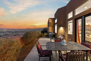 Patio terrace at dusk featuring outdoor dining area, grilling area, and a patio area