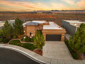 View of front of home featuring stucco siding, a mountain view, an attached garage, and driveway