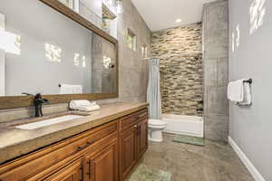 Bathroom with shower / tub combo, vanity, and recessed lighting