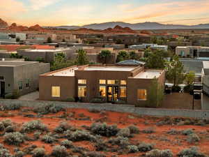 Back of property at dusk with stucco siding and a mountain view