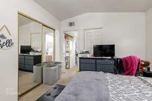 Bedroom with vaulted ceiling, carpet flooring, and a closet
