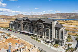 Drone / aerial view of apartment complex and a water and mountain view