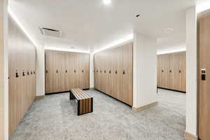 Hallway featuring light carpet and baseboards