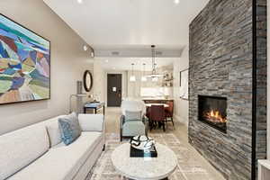 Living room with light wood-style flooring, a fireplace, and recessed lighting