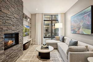 Living room featuring built in shelves, a fireplace, and wood finished floors