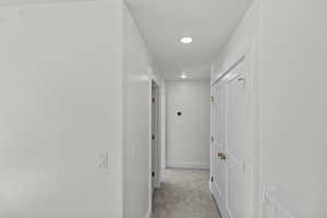 Hall featuring light carpet and recessed lighting