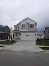 View of front of property with driveway, a front lawn, and a garage