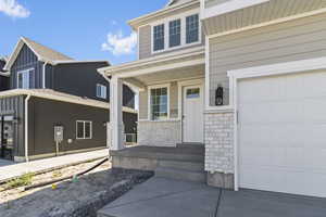 Doorway to property featuring covered porch and stone siding