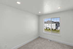 Carpeted spare room featuring baseboards and recessed lighting