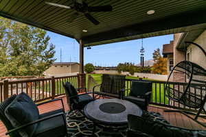 Wooden deck with ceiling fan and a fenced backyard