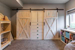 Bedroom with carpet flooring and a barn door