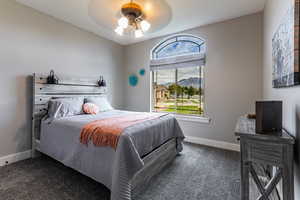 Carpeted bedroom with a mountain view and a ceiling fan