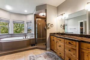Full bathroom with vanity, a garden tub, a shower stall, and light tile patterned floors