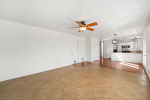 Unfurnished living room featuring ceiling fan and light tile patterned floors