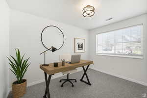 Home office with light colored carpet and baseboards