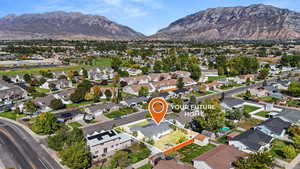 Aerial overview of property's location featuring a mountainous background and nearby suburban area