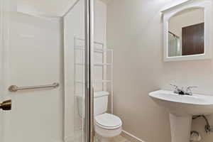 Full bathroom featuring a stall shower and tile patterned flooring