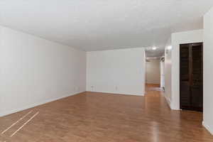 Empty room featuring light wood-style flooring and a textured ceiling