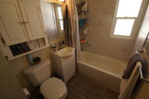 Full bath with shower / bath combination with curtain and vanity