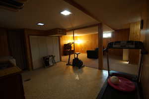 Basement featuring wooden walls and light flooring