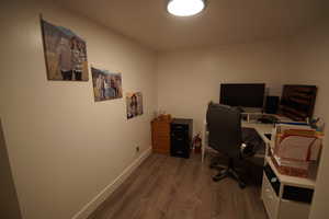 Office space with dark wood-style flooring and baseboards