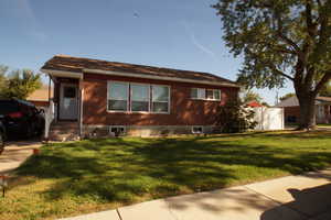 View of front of house with a front yard and brick siding