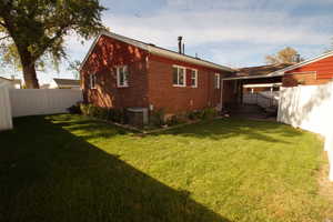 View of side of property with a fenced backyard and brick siding
