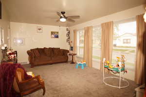 Living area featuring carpet floors and ceiling fan