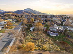Aerial view of property and surrounding area with mountains and nearby suburban area