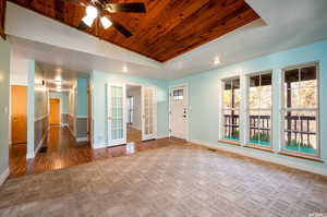 Empty room featuring vaulted ceiling, wooden ceiling, carpet flooring, a ceiling fan, and recessed lighting