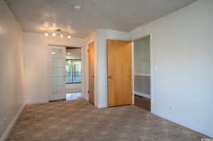 Unfurnished room with carpet flooring and a textured ceiling