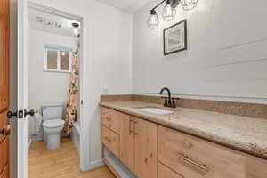 Bathroom with vanity, light wood-type flooring, and shower / bathtub combination with curtain