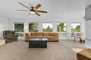 Living area featuring light carpet, recessed lighting, and a ceiling fan