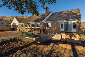 Back of property with brick siding, a patio area, and a chimney