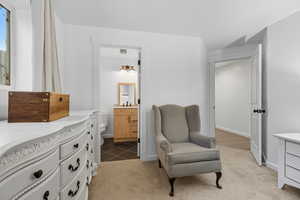 Living area with light colored carpet and baseboards