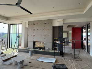 Living room featuring a tray ceiling and floor to ceiling windows