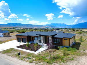 Prairie-style home with driveway, a mountain view, and a garage