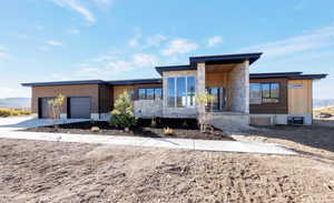 Contemporary house featuring driveway, covered porch, and a garage