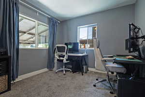 Office space with baseboards and light carpet