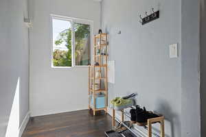 Living area with dark wood-type flooring and baseboards